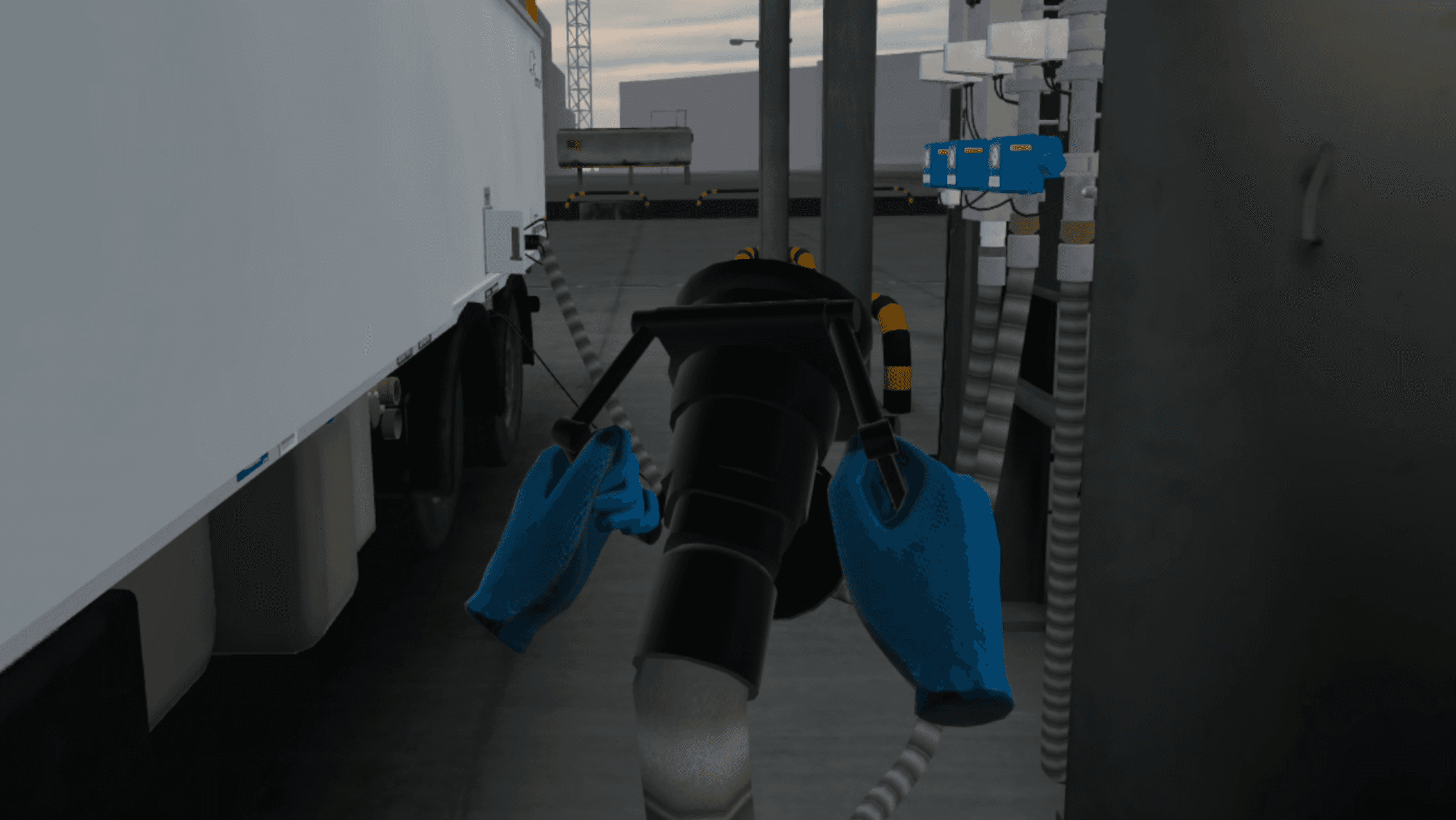 Behandschuhte Hände führen eine Schlauchkupplung neben dem Tankwagen in Position, das Erdungskabel daneben verlegt.
