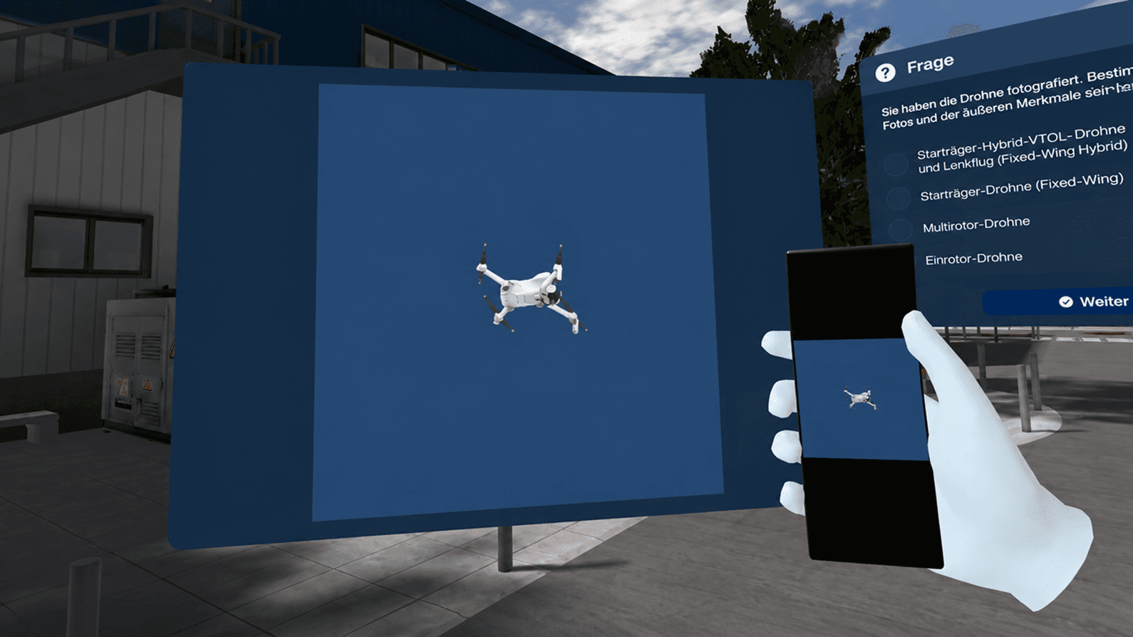 Una mano tiene un telefono che mostra una foto di un drone accanto a una domanda a scelta multipla su quale tipo di drone sia, un grande schermo che mostra la stessa foto accanto.
